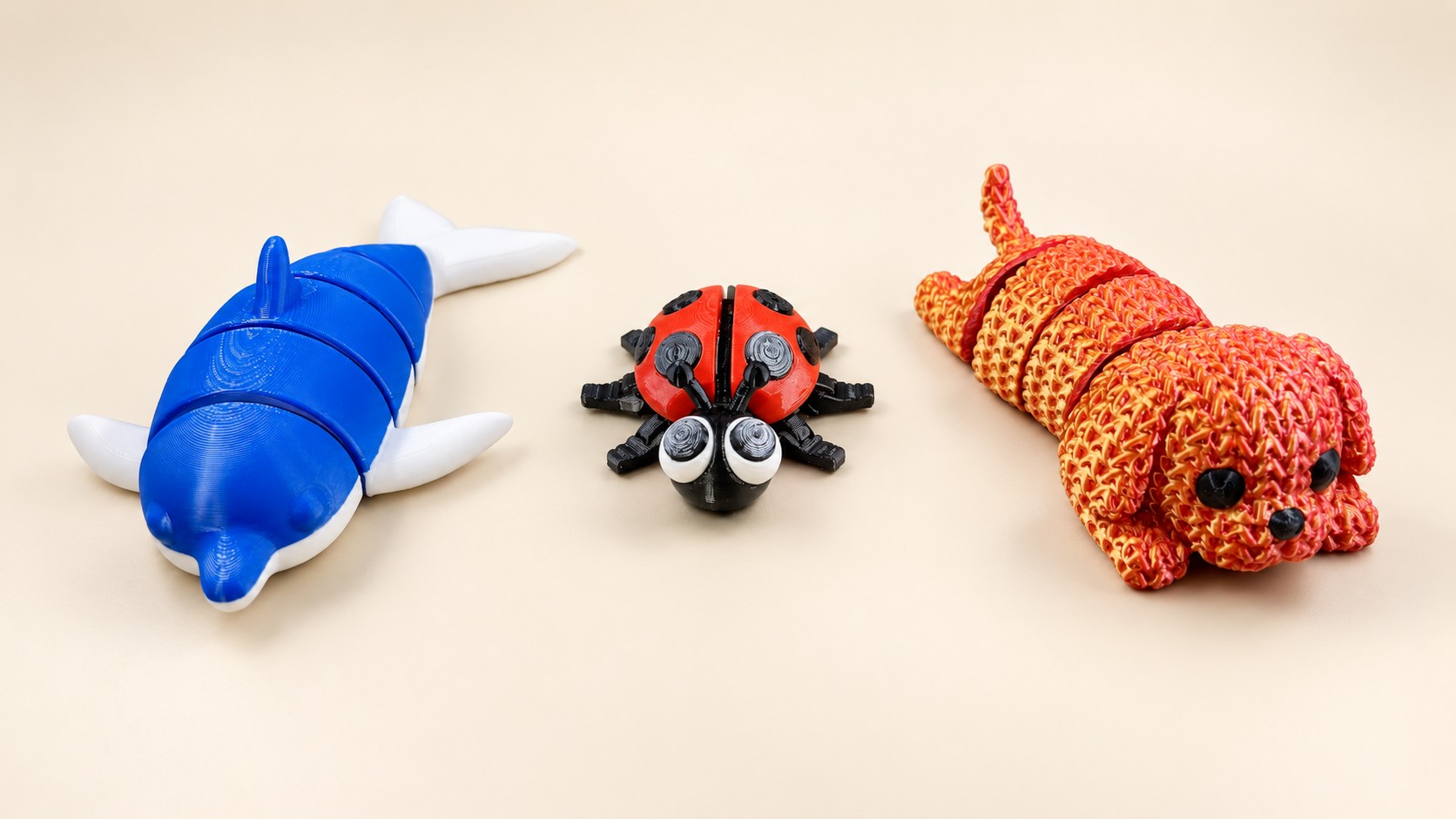 Blue dolphin, red and black ladybug, and red gold segmented animal figures.