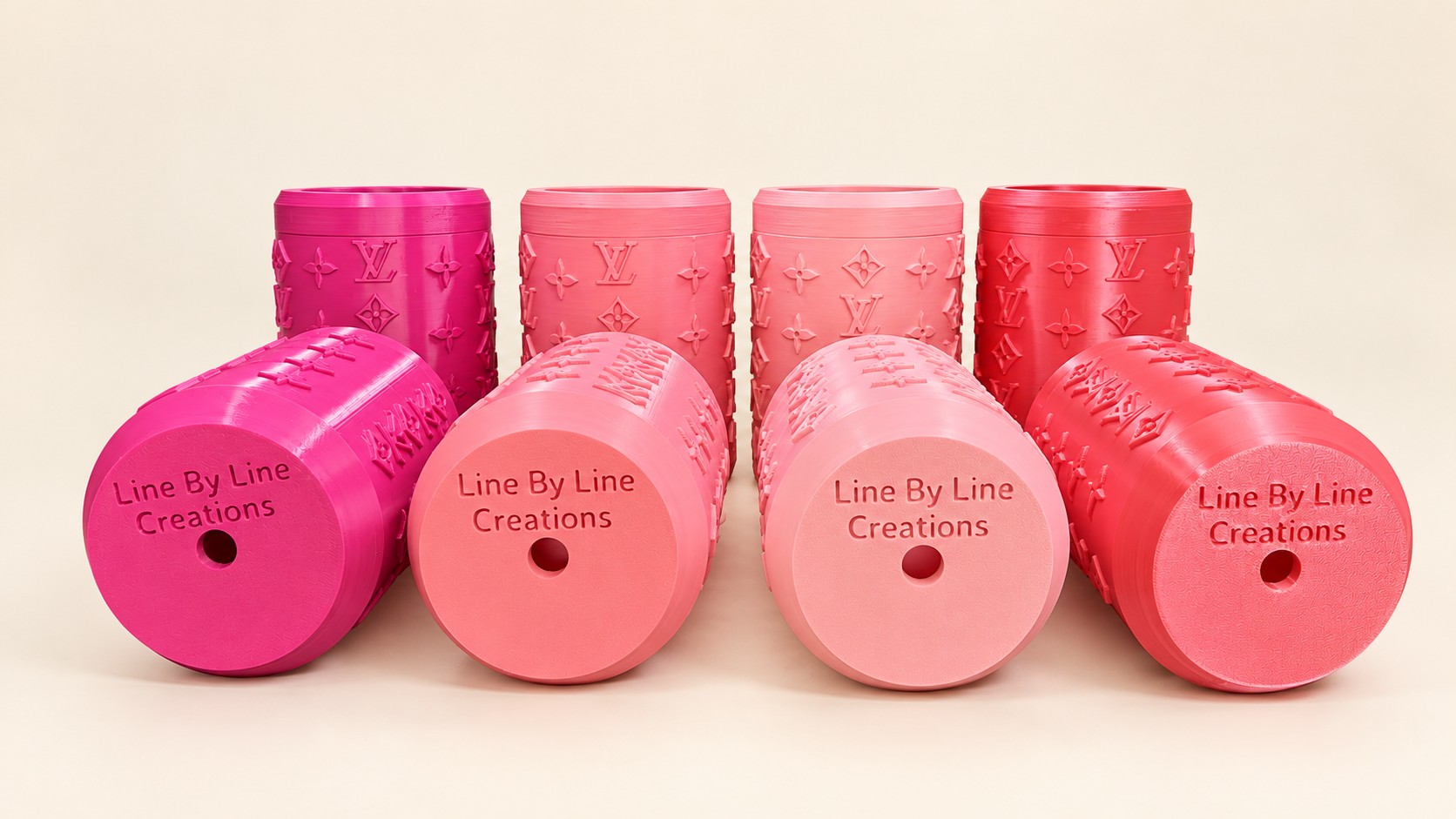 Pink and coral custom can koozies with engraved business names on their bases.