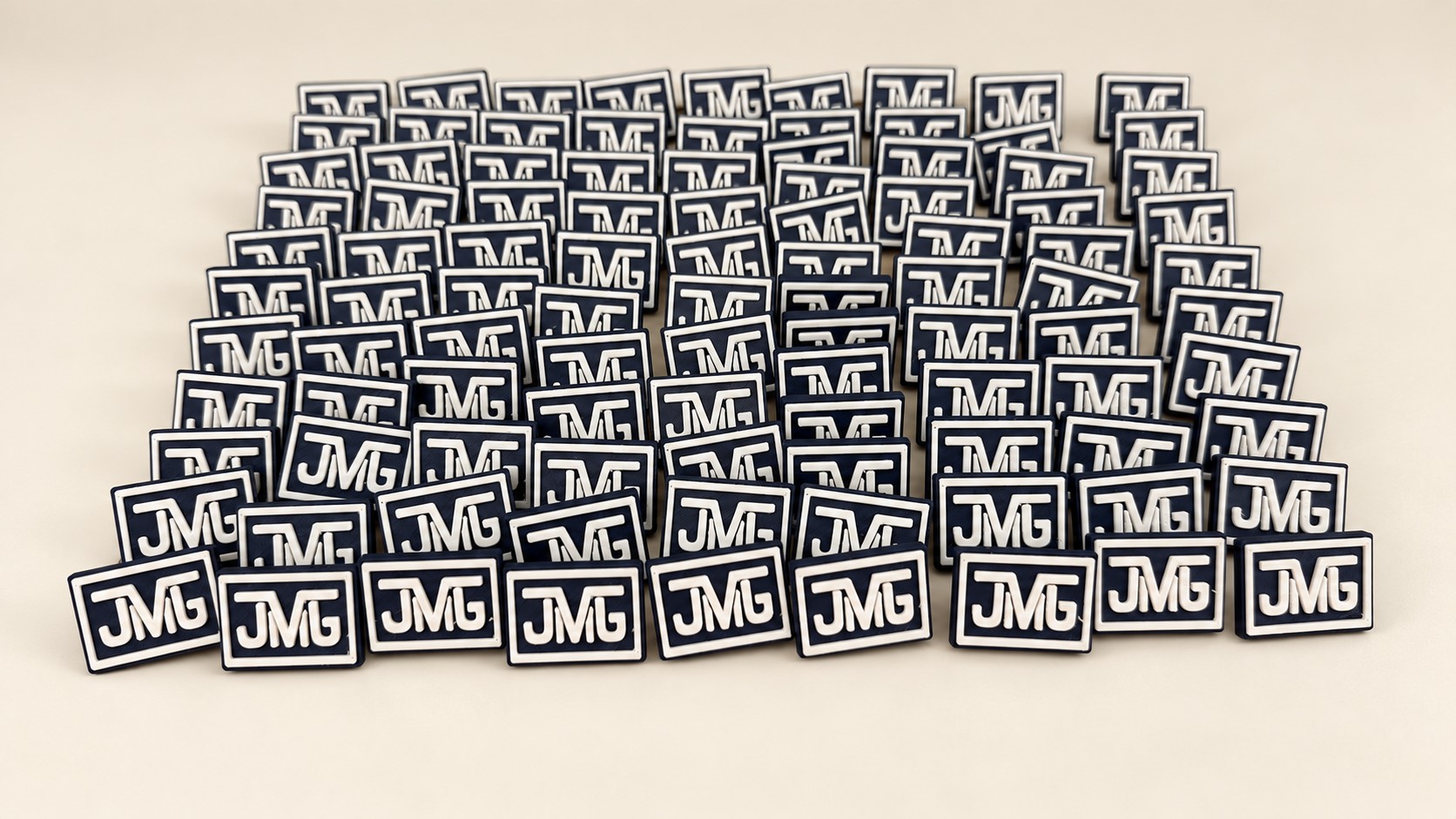Navy and white JMG logo pins on a neutral ivory background.