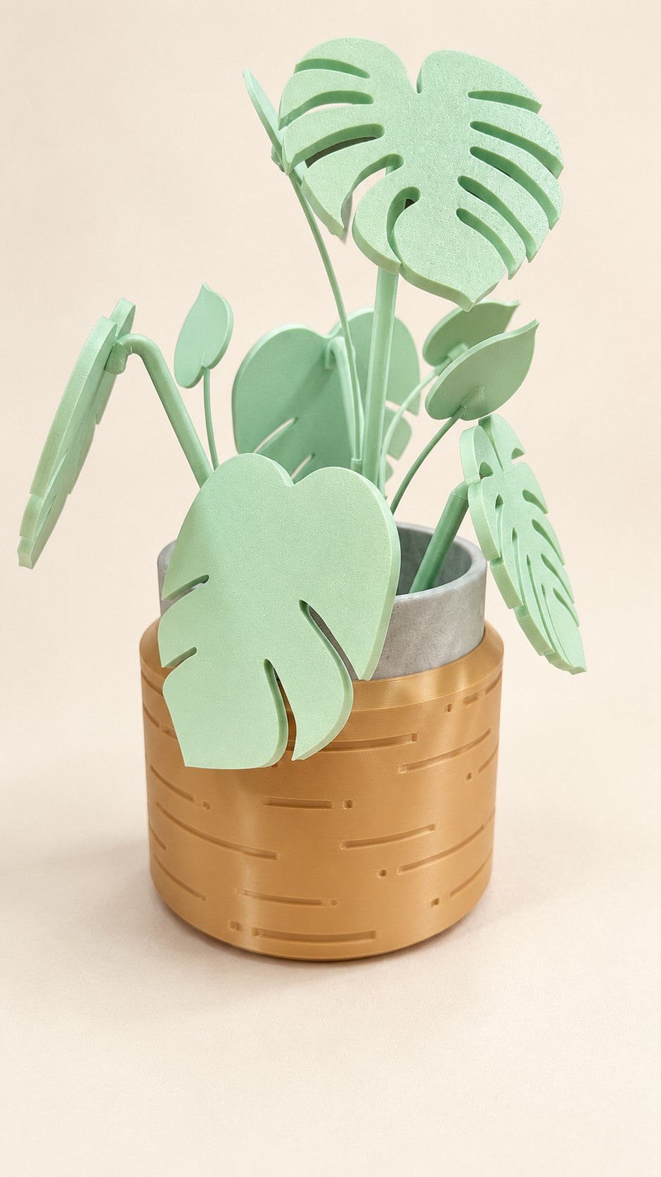 Pale green decorative printed leaves in a golden tan pot.