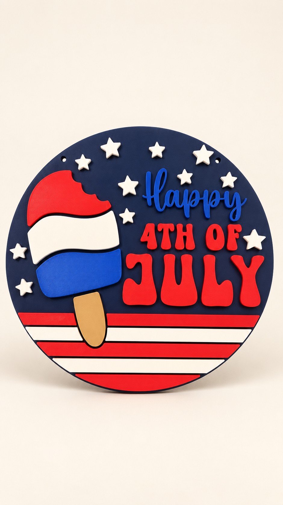 Round navy Happy 4th of July sign with raised stars and a red white and blue popsicle.