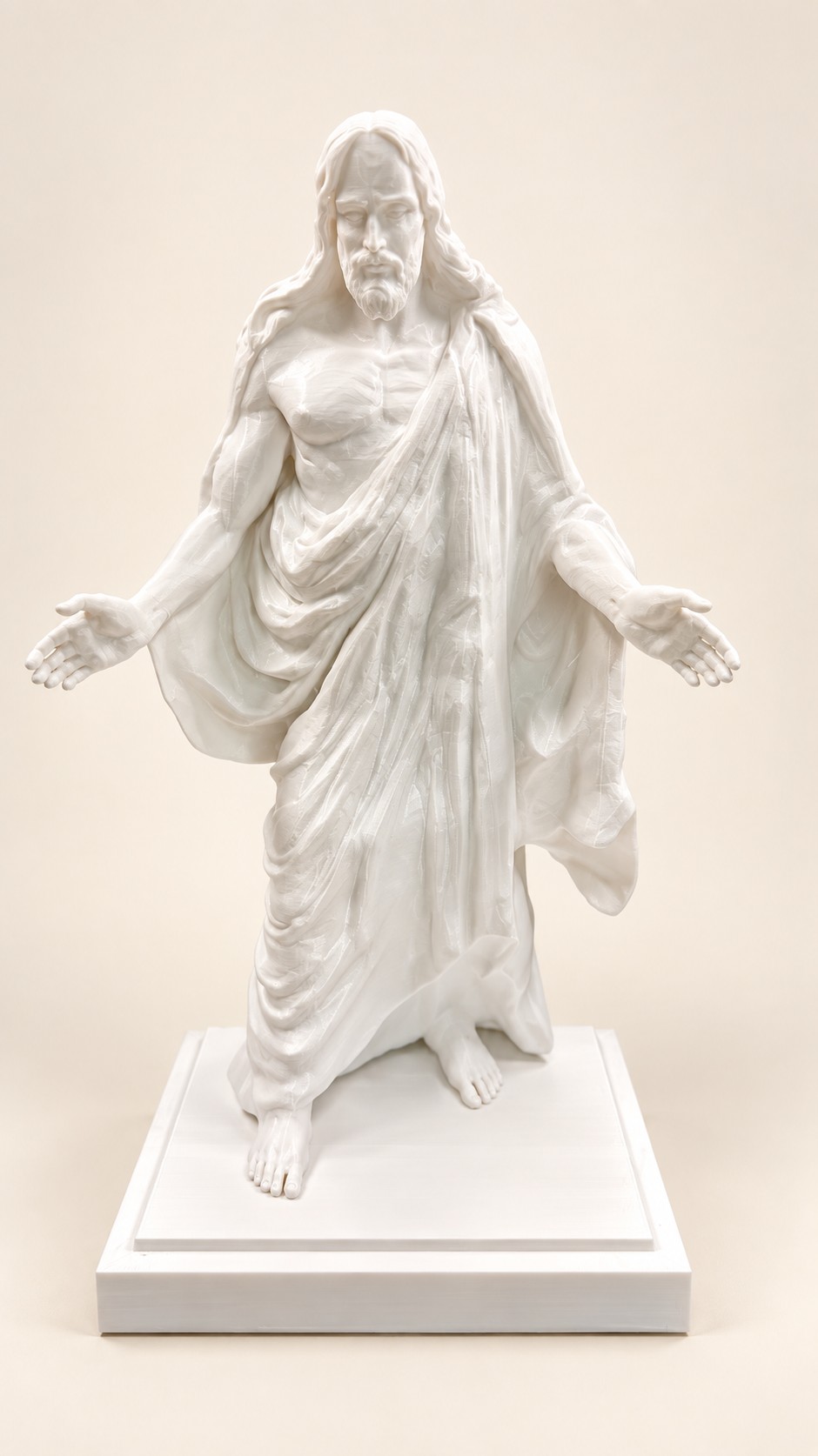 White statue of Jesus with open arms on a square pedestal.